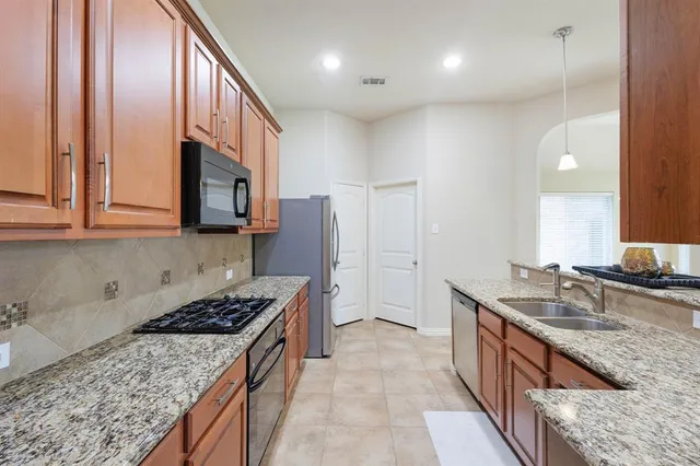 a kitchen with stainless steel appliances granite countertop a stove a sink a refrigerator and a oven