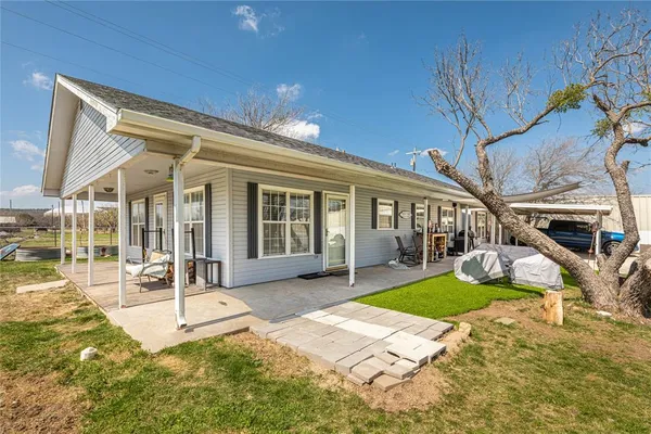 a view of a house with backyard and sitting area