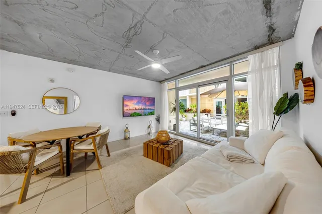 a living room with furniture a flat screen tv and a large window