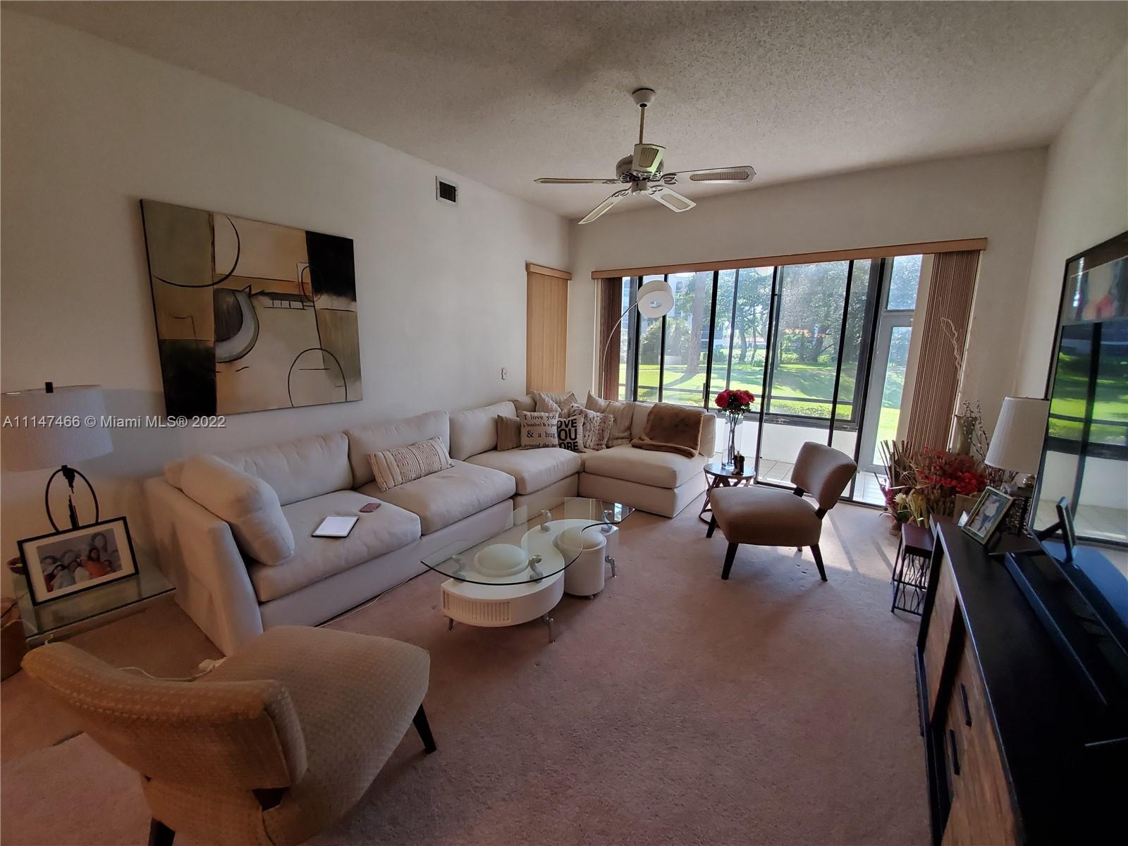 7472 La Paz Boulevard, Unit 104 Boca Raton, FL 33433 - Photo 14 of 44 a living room with furniture and a large window