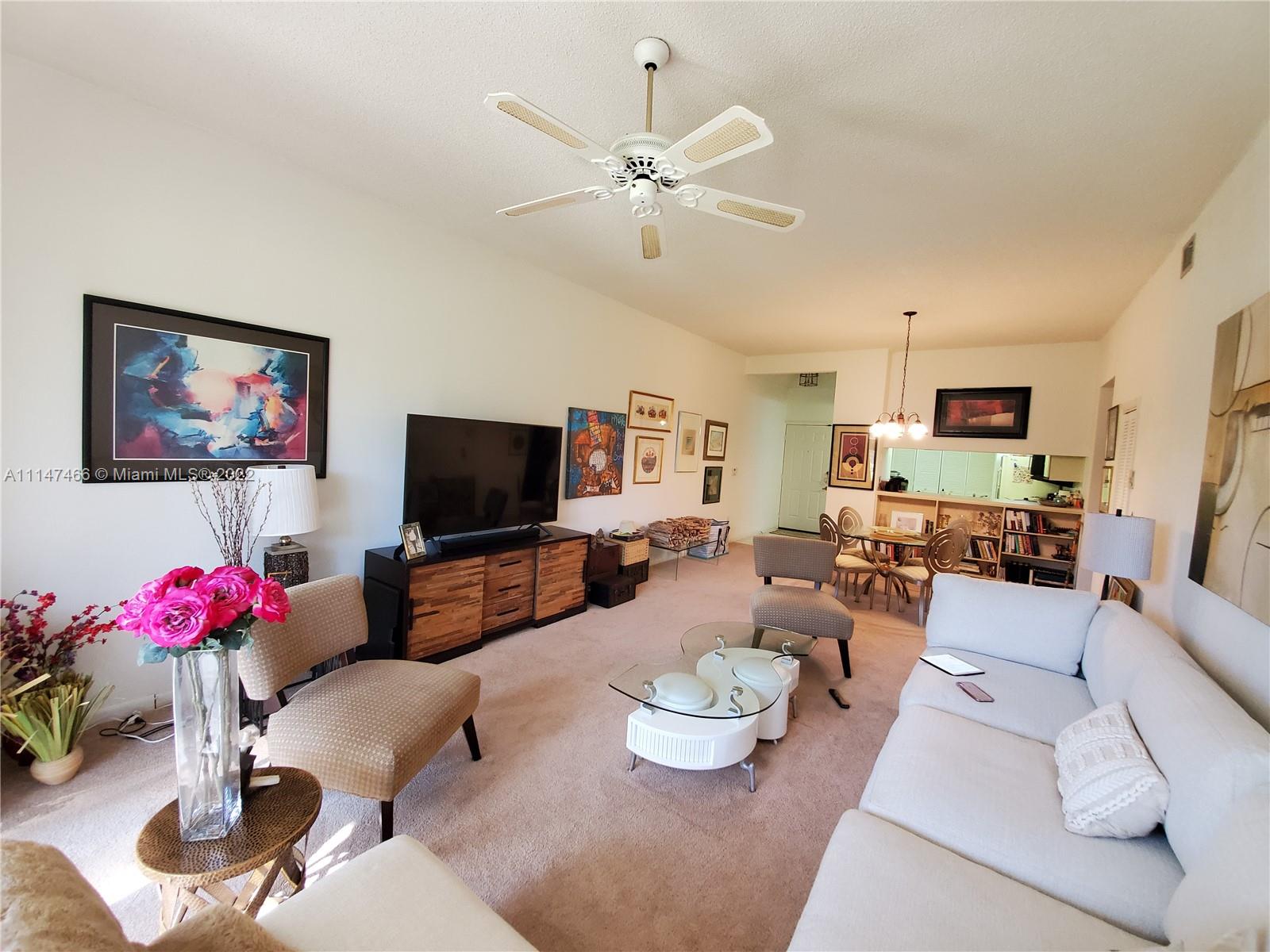 7472 La Paz Boulevard, Unit 104 Boca Raton, FL 33433 - Photo 16 of 44 a living room with furniture kitchen view and a flat screen tv
