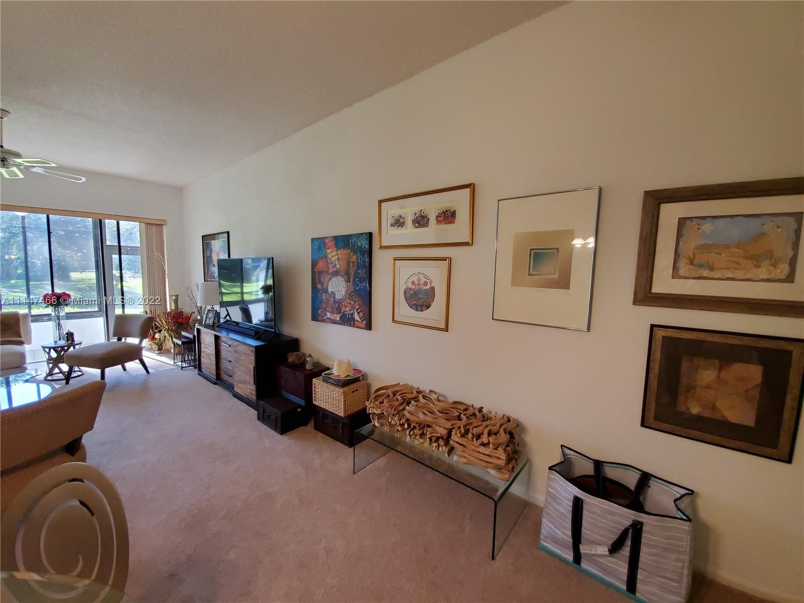 7472 La Paz Boulevard, Unit 104 Boca Raton, FL 33433 - Photo 17 of 44 a living room with furniture and a window