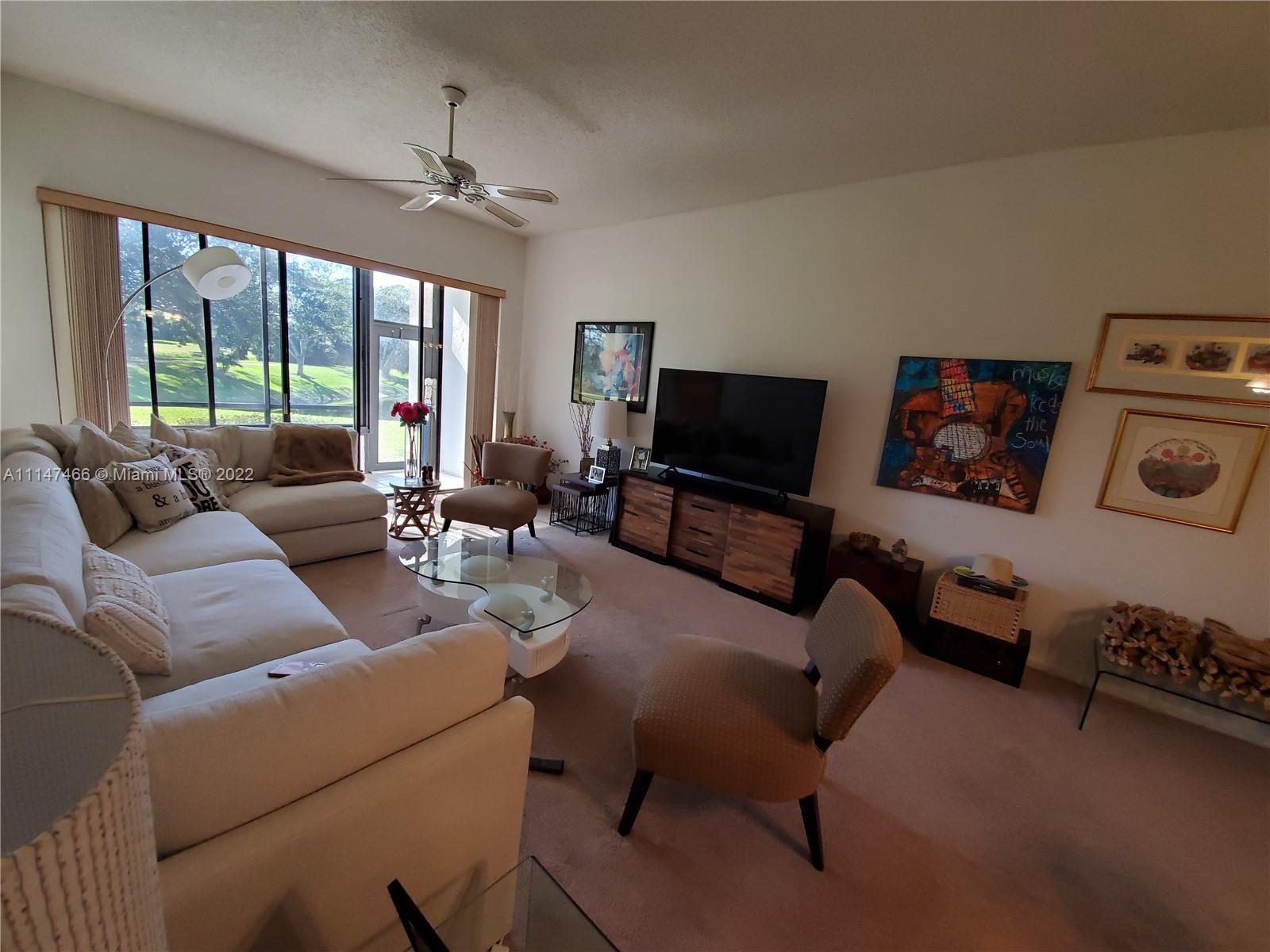 7472 La Paz Boulevard, Unit 104 Boca Raton, FL 33433 - Photo 18 of 44 a living room with furniture and a flat screen tv