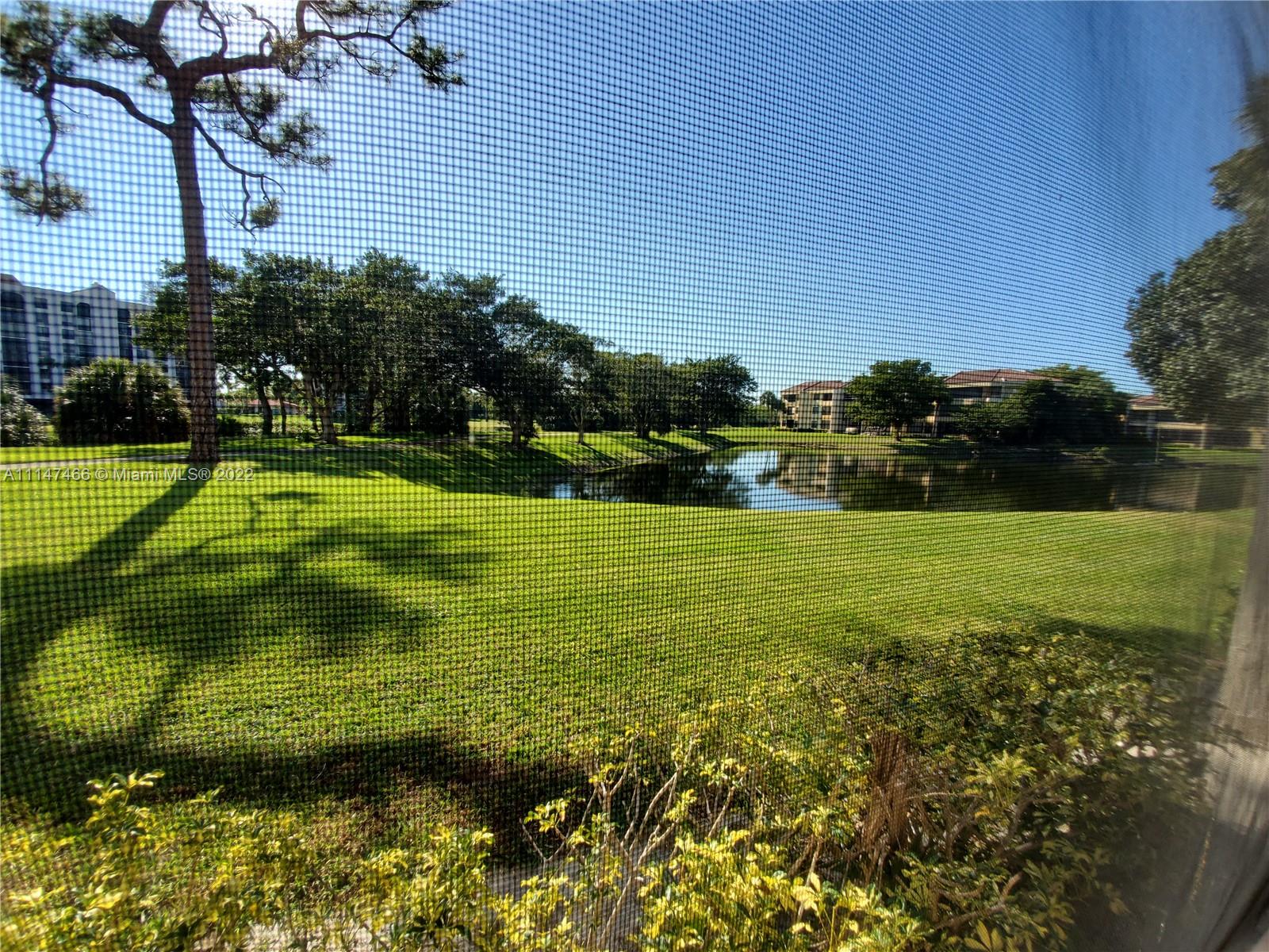 7472 La Paz Boulevard, Unit 104 Boca Raton, FL 33433 - Photo 24 of 44 a view of a garden with a building in the background