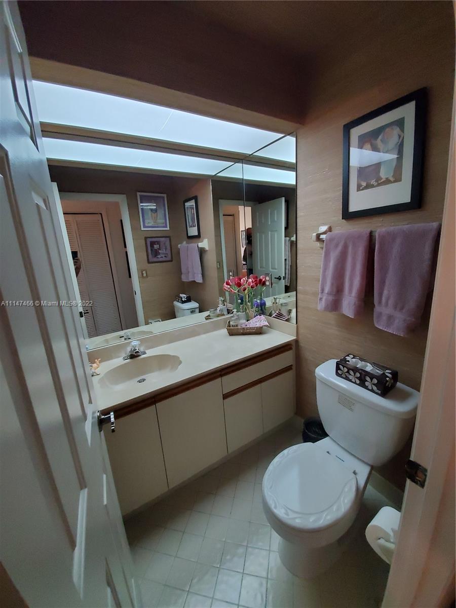 7472 La Paz Boulevard, Unit 104 Boca Raton, FL 33433 - Photo 29 of 44 a bathroom with a toilet sink and mirror