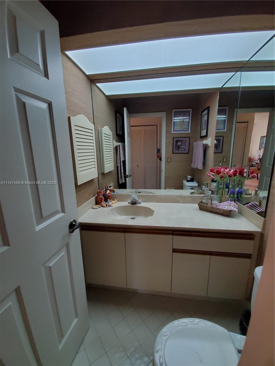 7472 La Paz Boulevard, Unit 104 Boca Raton, FL 33433 - Photo 30 of 44 a bathroom with a toilet sink and mirror