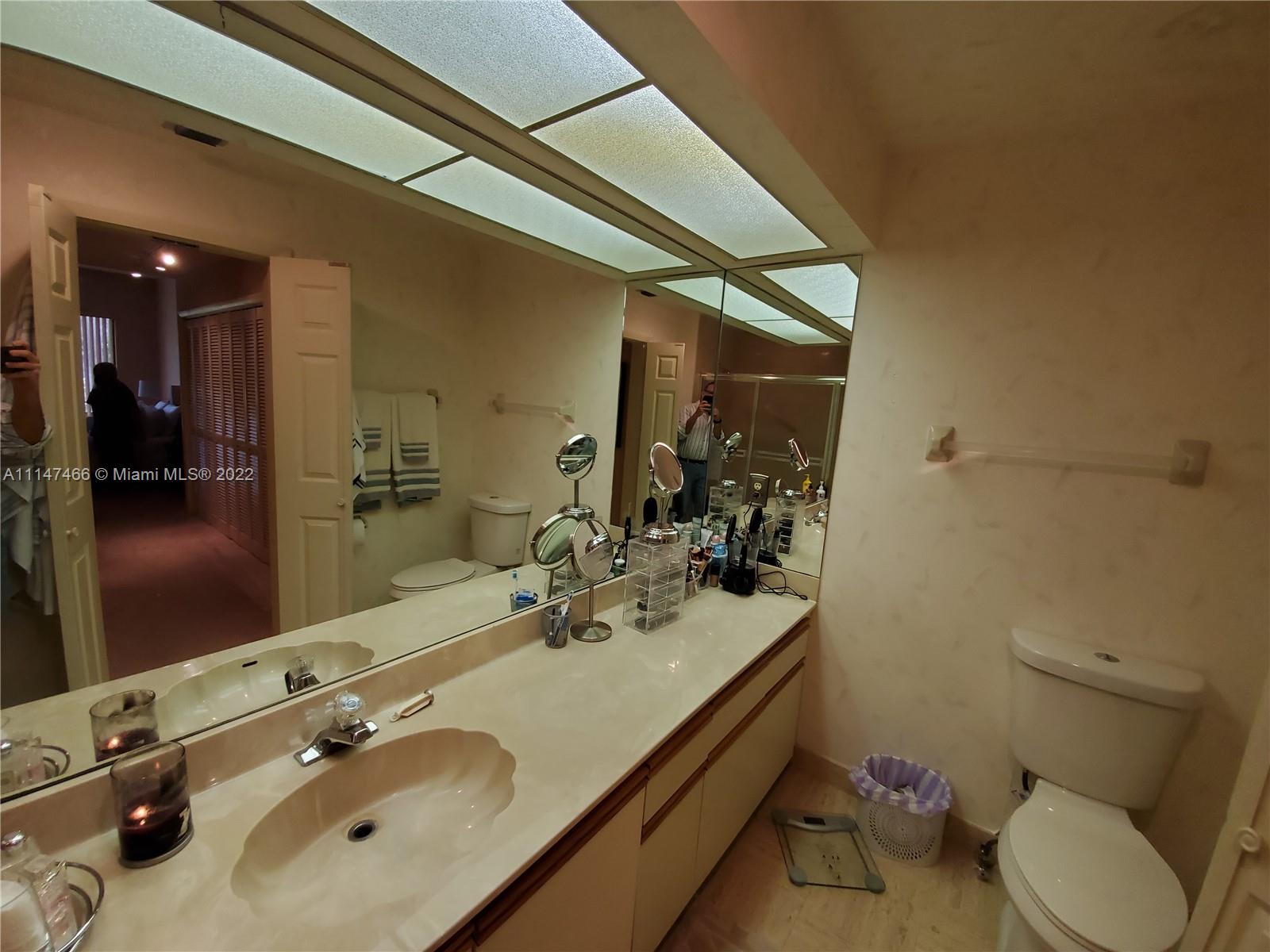 7472 La Paz Boulevard, Unit 104 Boca Raton, FL 33433 - Photo 32 of 44 a bathroom with a sink double vanity and a toilet