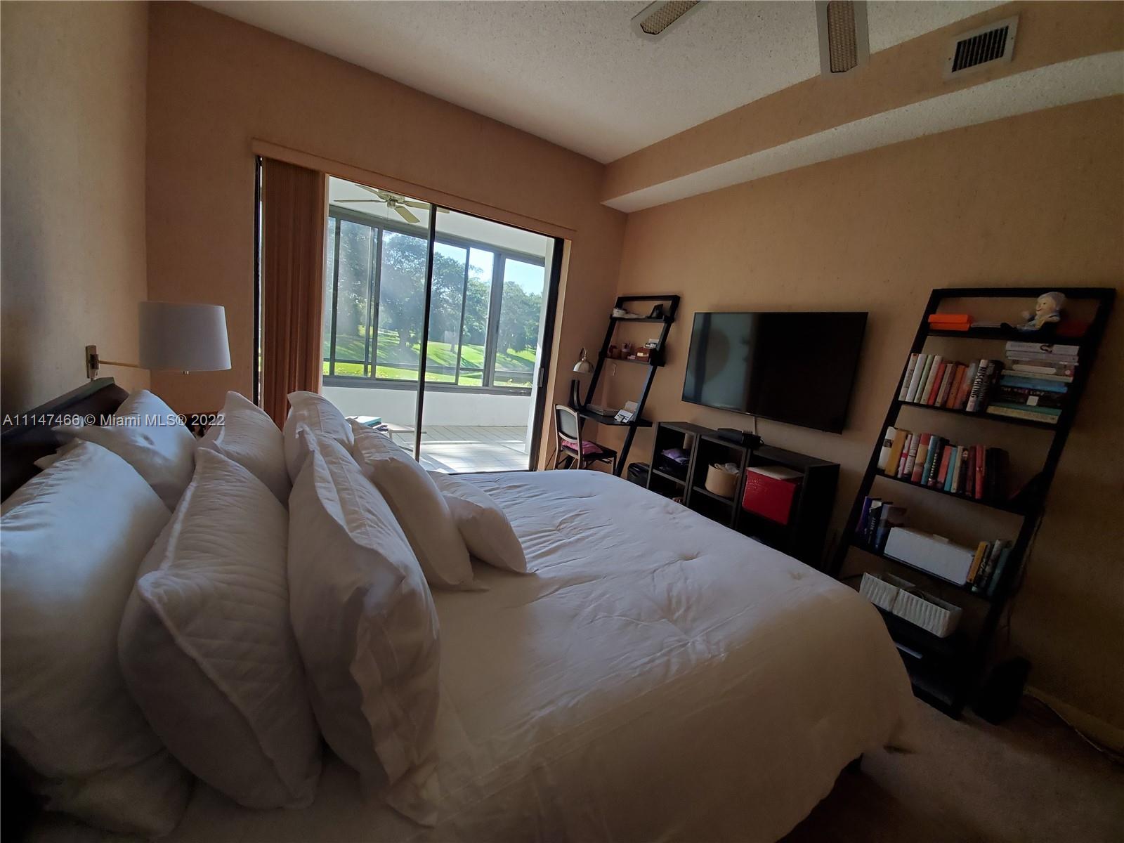 7472 La Paz Boulevard, Unit 104 Boca Raton, FL 33433 - Photo 37 of 44 a bed sitting in a bedroom next to a window