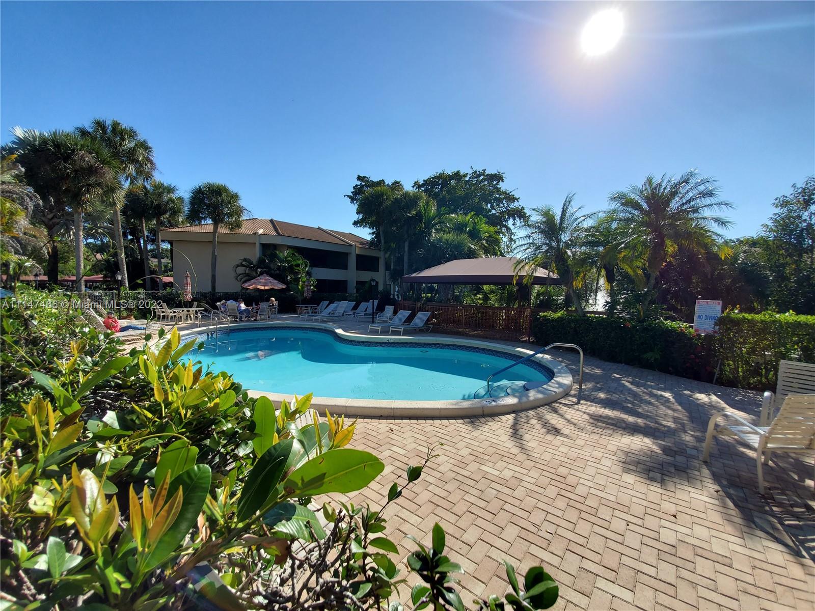 7472 La Paz Boulevard, Unit 104 Boca Raton, FL 33433 - Photo 43 of 44 a view of a swimming pool with a patio