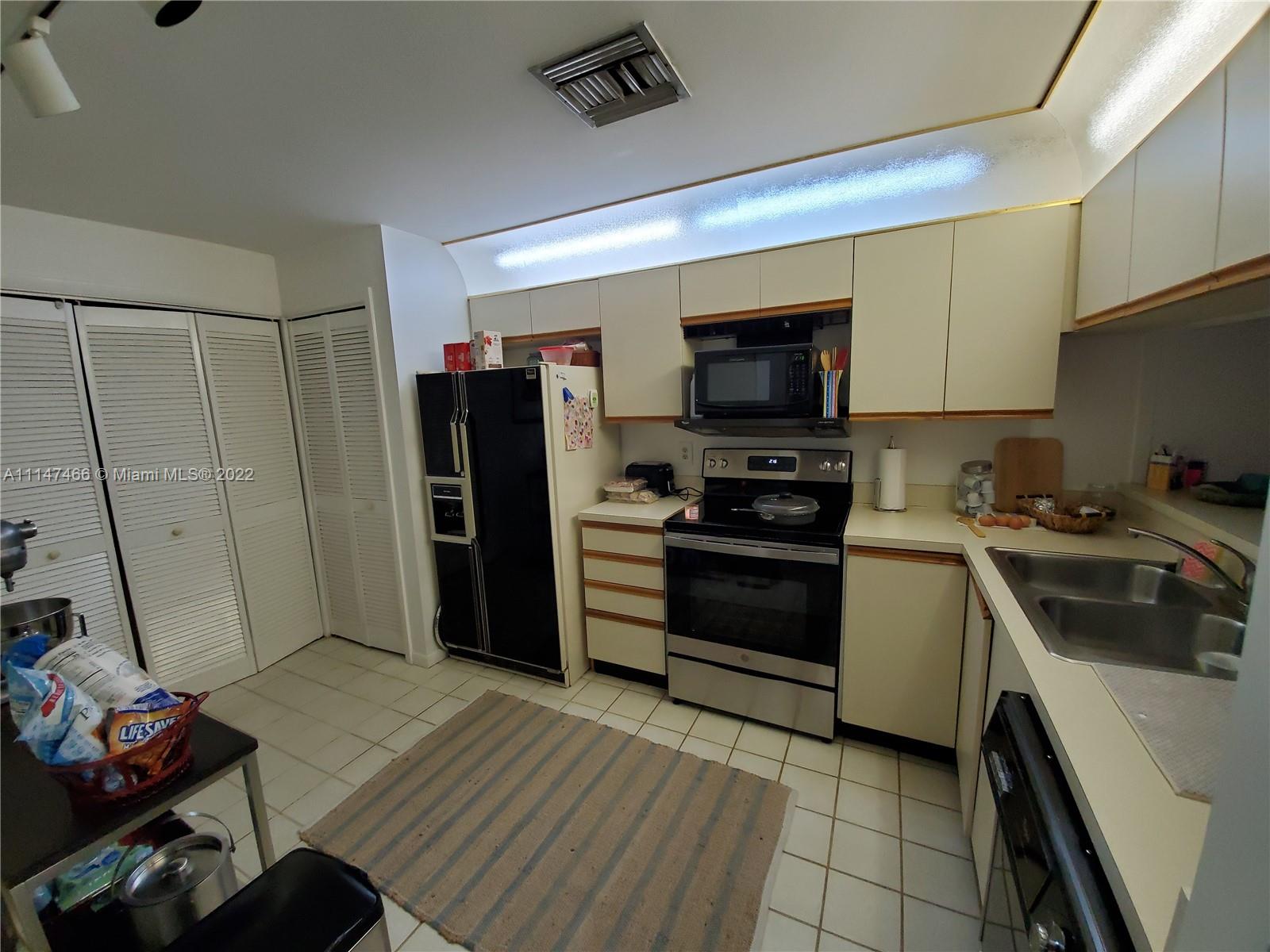 7472 La Paz Boulevard, Unit 104 Boca Raton, FL 33433 - Photo 5 of 44 a kitchen with stainless steel appliances a stove microwave and a refrigerator