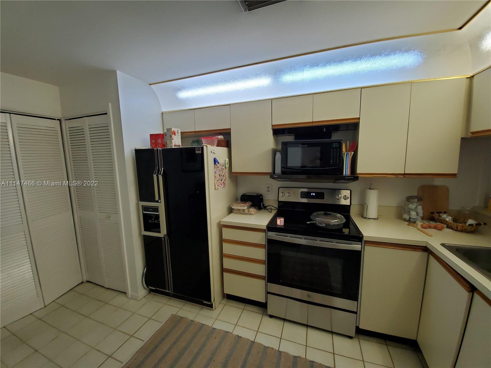 7472 La Paz Boulevard, Unit 104 Boca Raton, FL 33433 - Photo 6 of 44 a kitchen with a stove a refrigerator and a sink
