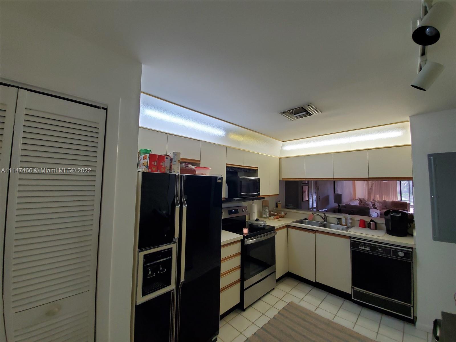 7472 La Paz Boulevard, Unit 104 Boca Raton, FL 33433 - Photo 7 of 44 a kitchen with stainless steel appliances a refrigerator sink and stove top oven