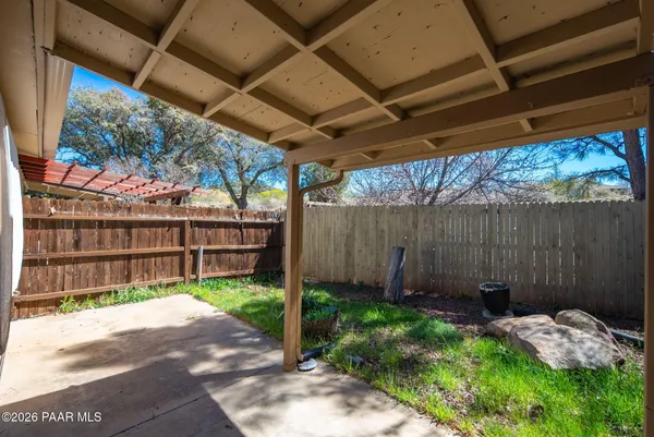 a view of a backyard with table and chairs and wooden fence