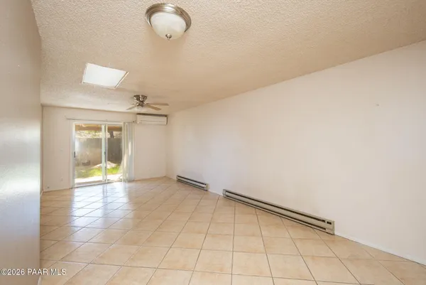 an empty room with fan and windows