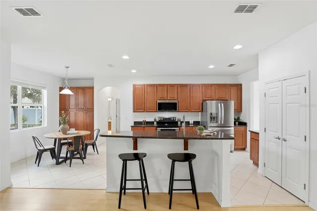 a kitchen with stainless steel appliances kitchen island granite countertop a refrigerator and cabinets