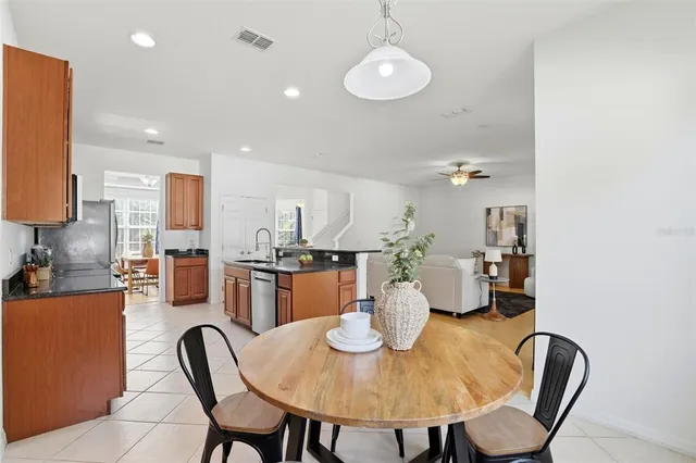 a kitchen with stainless steel appliances granite countertop a refrigerator a stove a sink dishwasher with a dining table and chairs