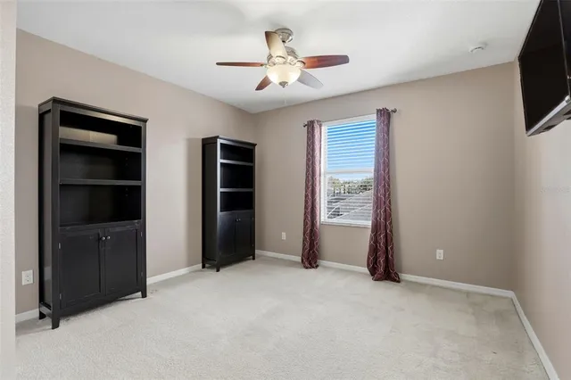 a view of an empty room with a ceiling fan and a window