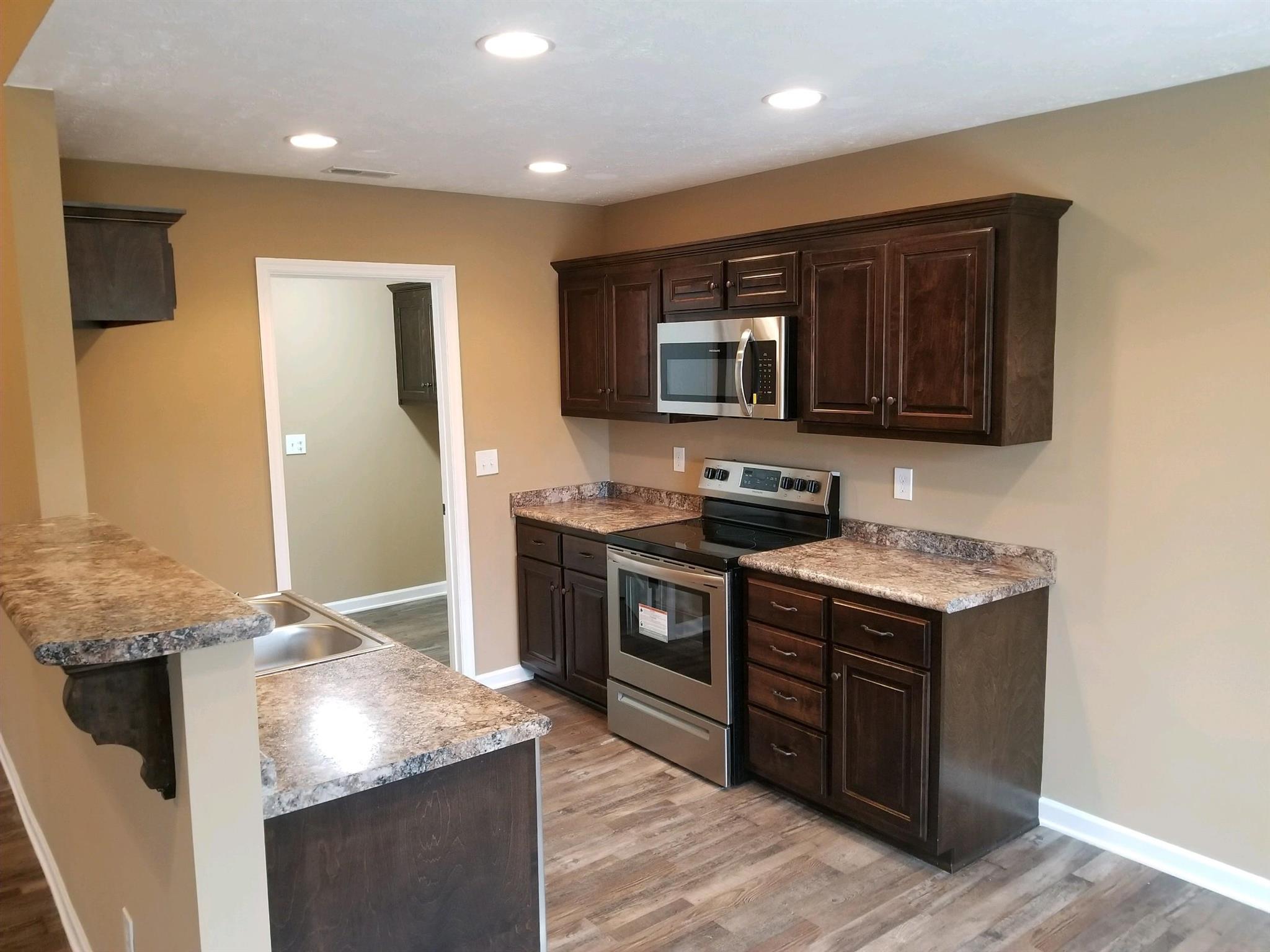320 Oak Hollow Road Manchester, TN 37355 - Photo 4 of 9 a kitchen with stainless steel appliances granite countertop a stove a sink and a microwave