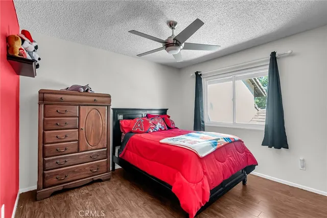 a bedroom with a bed and a flat tv screen on dresser