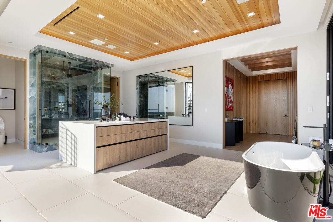 1033 Somera Road Los Angeles, CA 90077 - Photo 42 of 72 a large spacious bathroom with a granite countertop tub sink and mirror