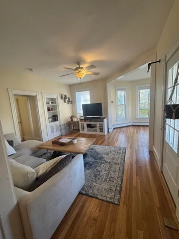 a living room with furniture and a wooden floor