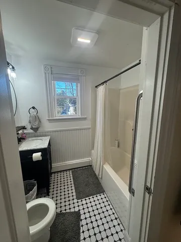 a bathroom with a sink a toilet a mirror and shower