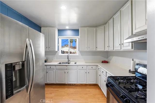 a kitchen with stainless steel appliances a sink stove and refrigerator
