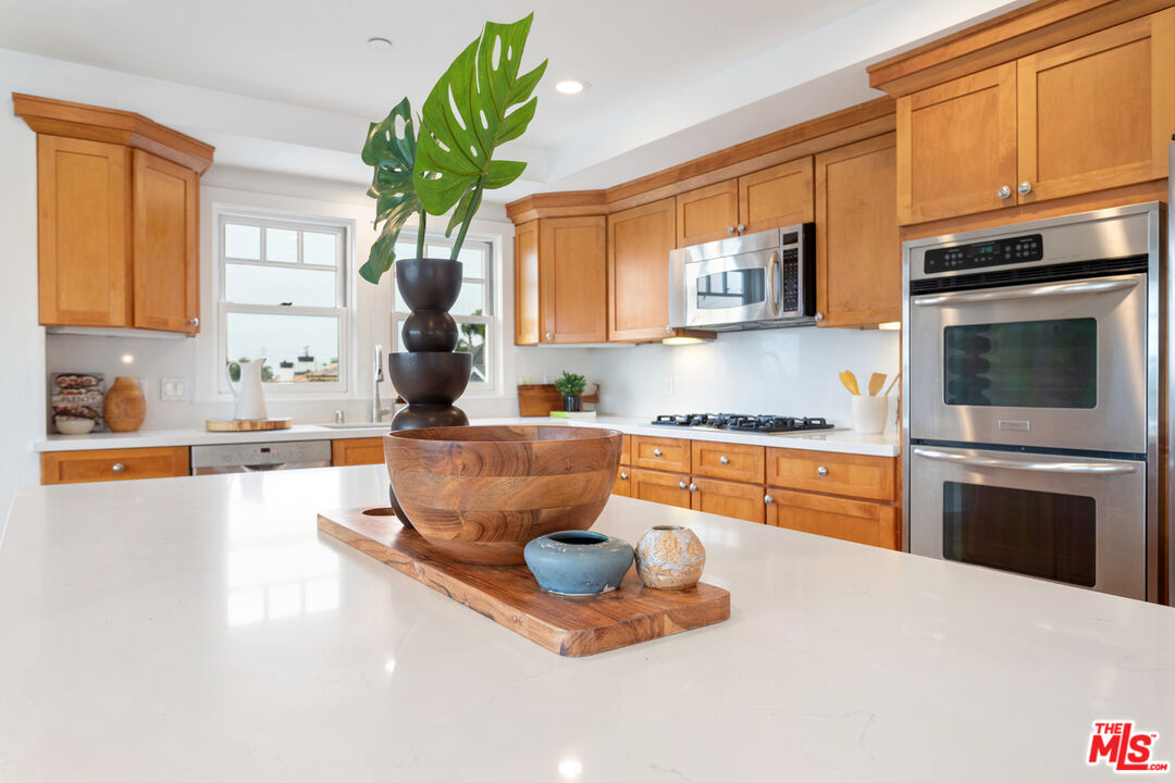625 Diamond Street Redondo Beach, CA 90277 - Photo 11 of 42 a kitchen with stainless steel appliances granite countertop a sink dishwasher stove and microwave with wooden floor