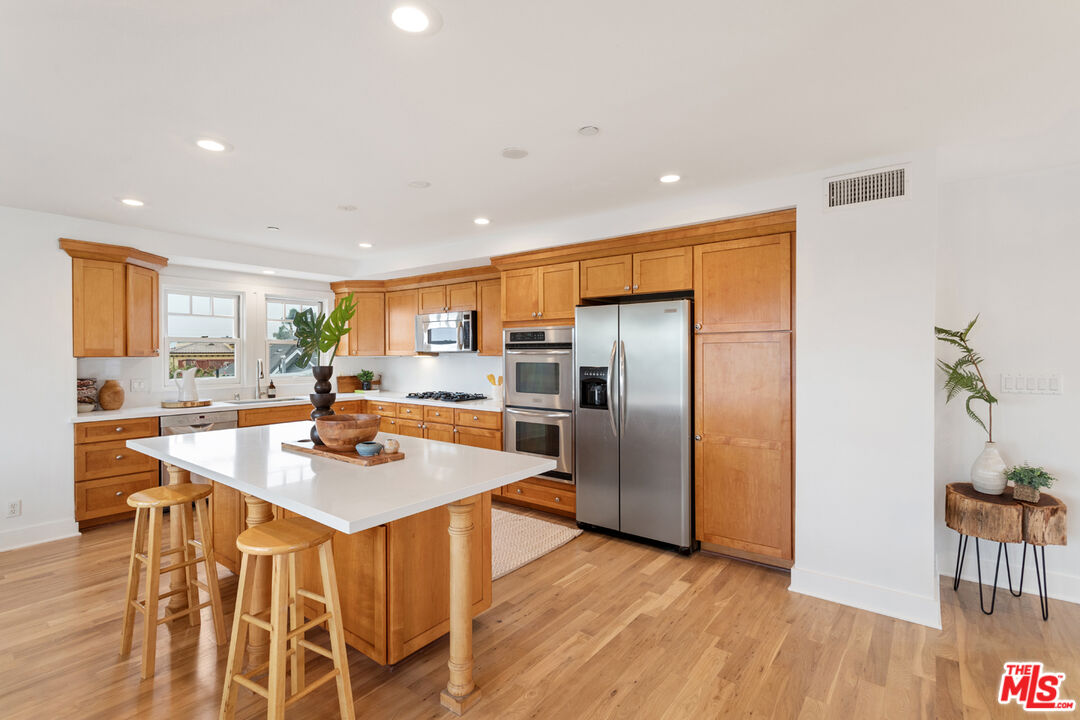 625 Diamond Street Redondo Beach, CA 90277 - Photo 9 of 42 a kitchen with stainless steel appliances granite countertop a refrigerator a sink a stove a dining table and chairs