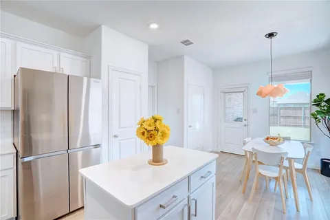 a kitchen with stainless steel appliances granite countertop a sink a refrigerator and a table