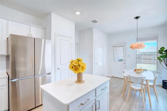 a kitchen with stainless steel appliances granite countertop a sink a refrigerator and a table