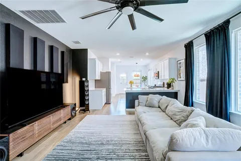 a living room with stainless steel appliances kitchen island granite countertop furniture and a flat screen tv