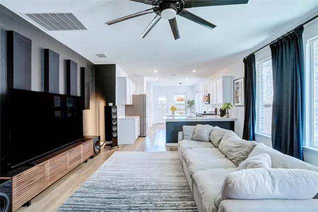 a living room with stainless steel appliances kitchen island granite countertop furniture and a flat screen tv