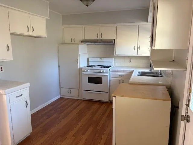 a kitchen with a stove sink and cabinets