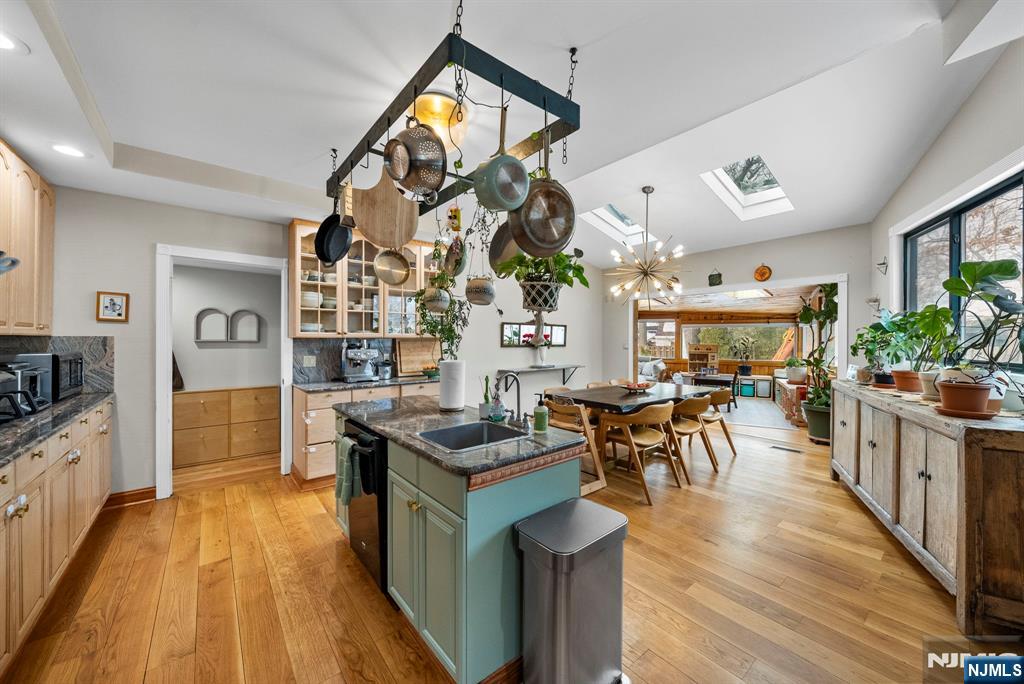 127 Hillside Avenue Cresskill, NJ 07626 - Photo 11 of 42 a view of a kitchen with kitchen island a counter top space a stove a dining table and chairs with wooden floor