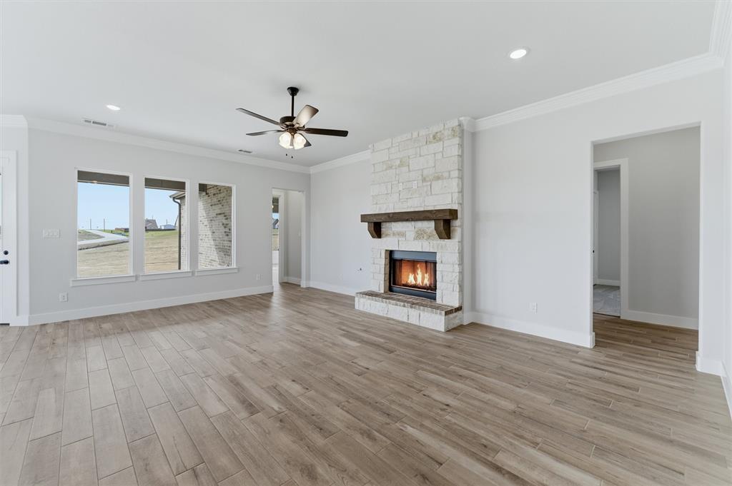 814 Vly Rdg Road Van Alstyne, TX 75495 - Photo 11 of 24 an empty room with wooden floor fireplace and windows