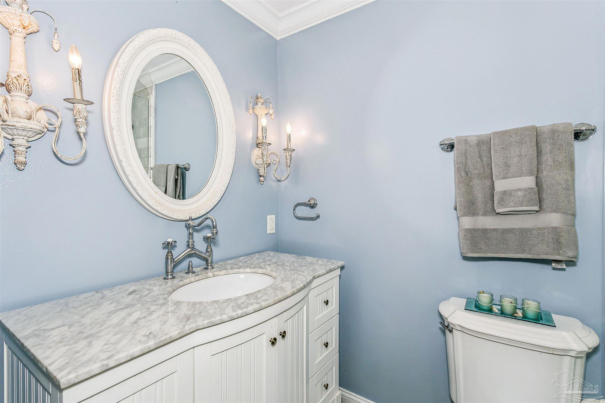 4831 East Olive Road, Unit 2D Pensacola, FL 32514 - Photo 23 of 29 a bathroom with a granite countertop toilet a sink and a mirror