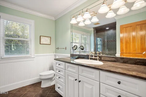a kitchen with stainless steel appliances granite countertop a dining table chairs and granite counter tops