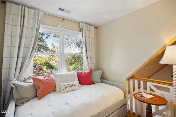 a kitchen with stainless steel appliances a stove a sink dishwasher a refrigerator and a dining table with wooden floor