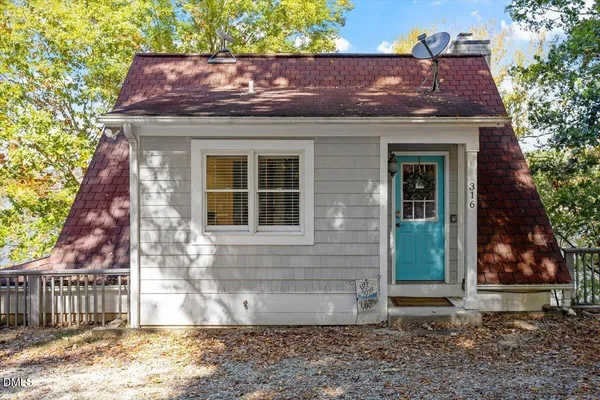 a view of a house with a yard and sitting area