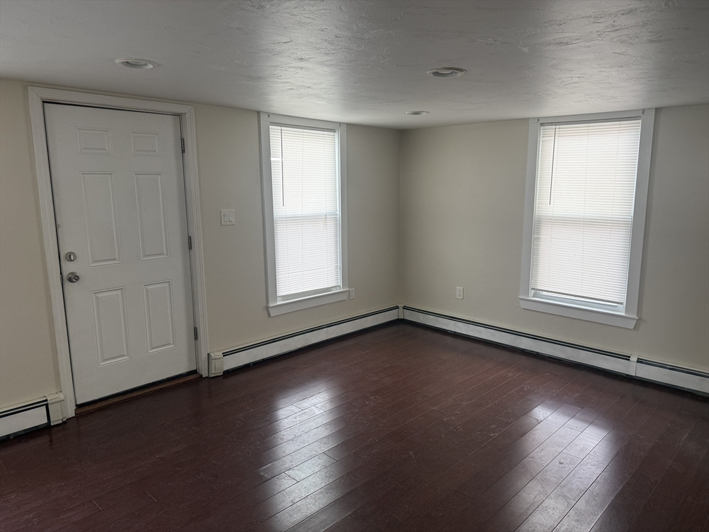 6 Ninth Street, Unit 1 Wareham, MA 02558 - Photo 4 of 15 an empty room with wooden floor and windows
