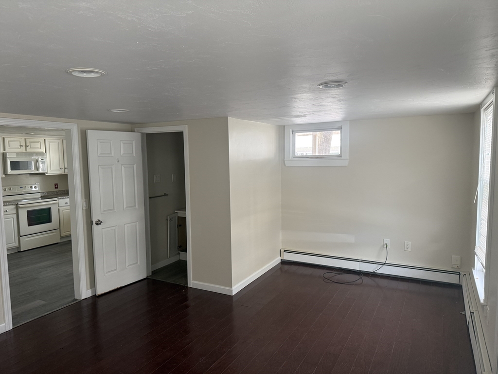 6 Ninth Street, Unit 1 Wareham, MA 02558 - Photo 6 of 15 an empty room with wooden floor and windows