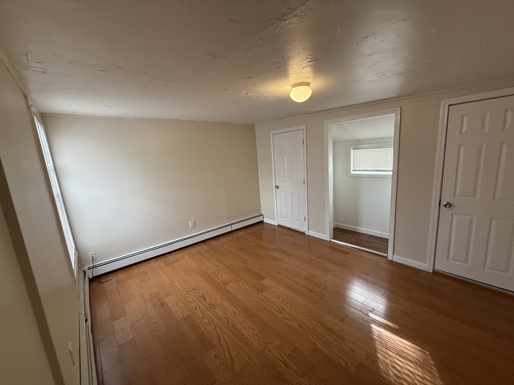 6 Ninth Street, Unit 1 Wareham, MA 02558 - Photo 8 of 15 an empty room with wooden floor and windows