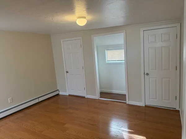 an empty room with wooden floor and closet