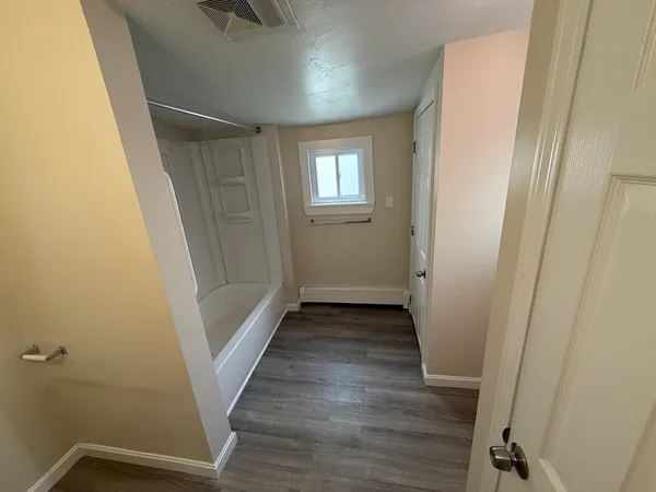 a view of a hallway with wooden floor