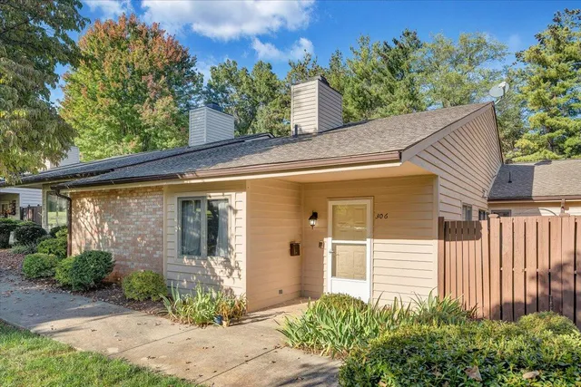 a view of a house with a small yard plants and large tree
