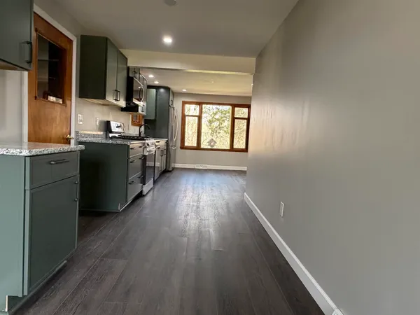 a kitchen with wooden floors and appliances