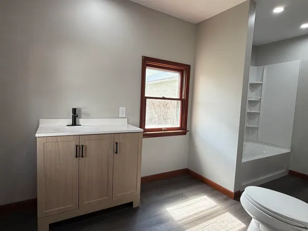 a bathroom with a sink a toilet and a window