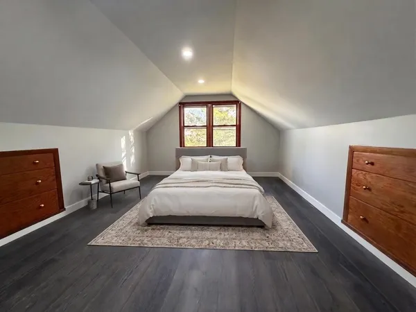 a spacious bedroom with a bed and a dresser