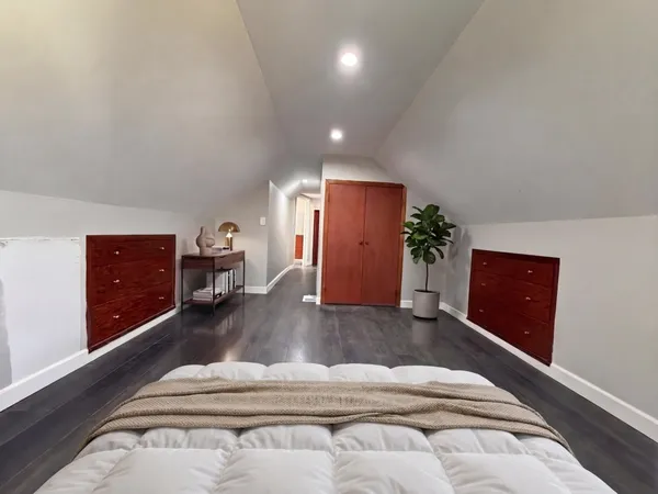 a spacious bedroom with a bed and a dresser
